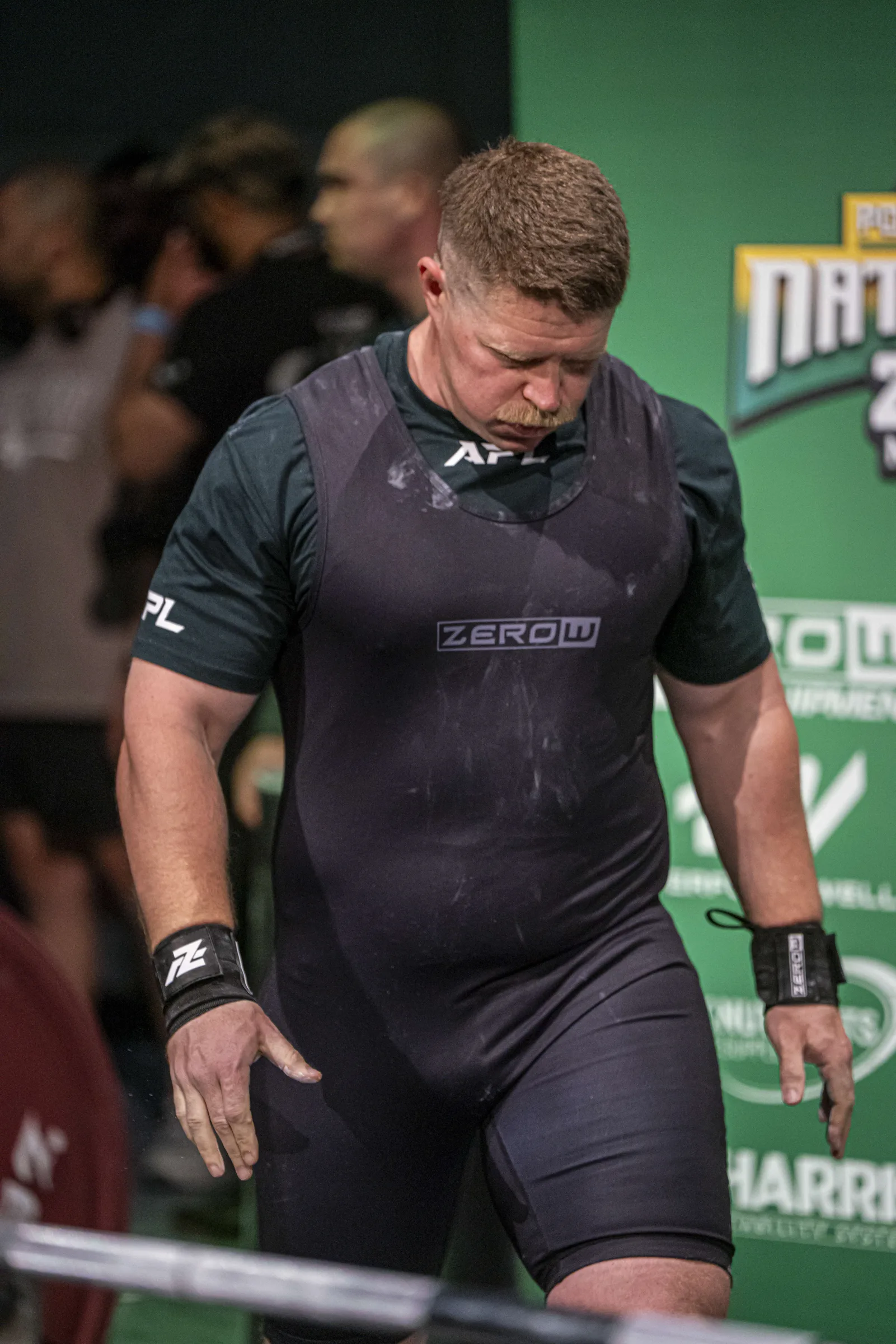 Abe Dearmer on the competition platform between attempts, chalk on his singlet.